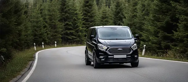 Carretera de montaña asfaltada entre bosques en el Valle de Arán. Servicio de taxi entre pueblos.
